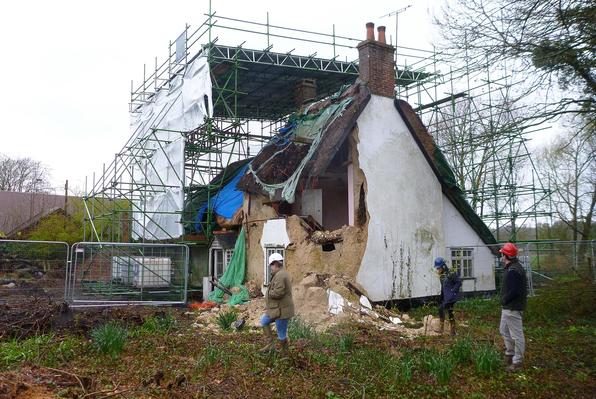 before photo of a dilapidated house with people looking