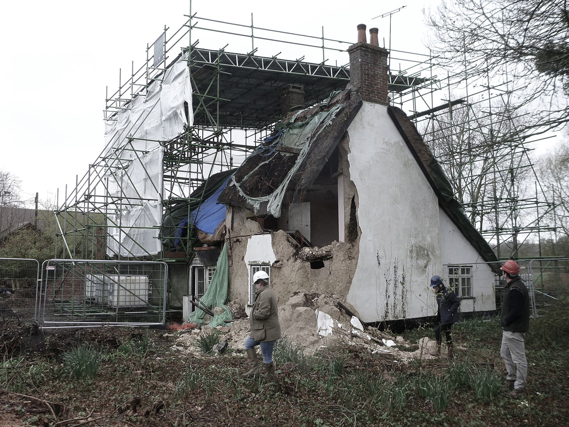 before photo of house with walls and thatched roof fallen down