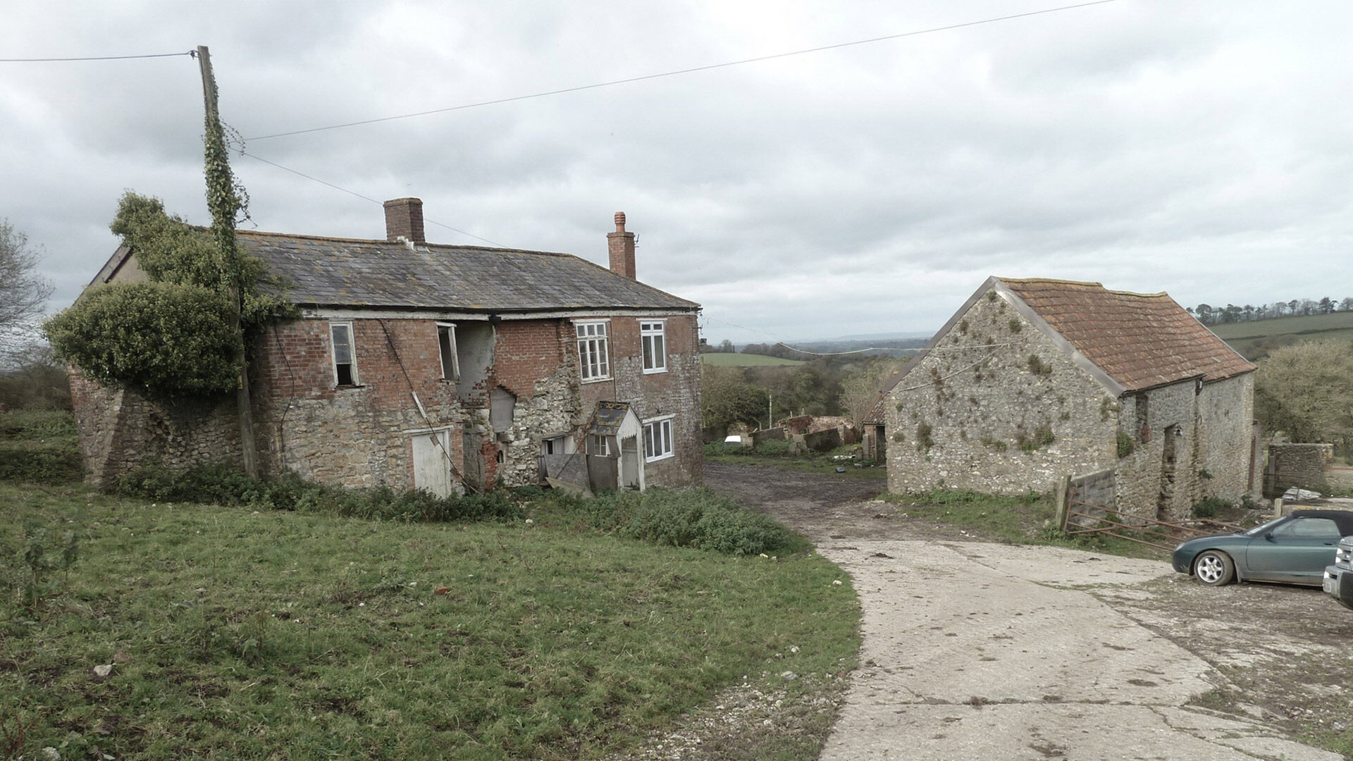 before photo of dilapidated barn and farmhouse in need of repair