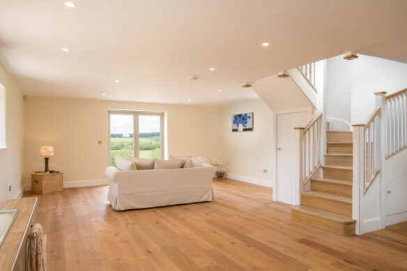 internal entrance in neutral tones with dog legged staircase and lovely country views through window