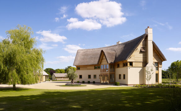 front view of unique curved house with thatched roof