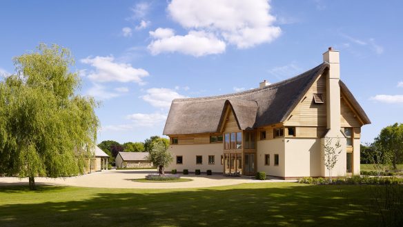 front view of unique curved house with thatched roof