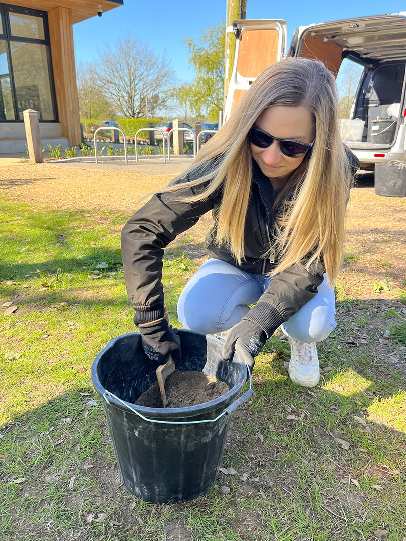 woman mixing soil in bucket