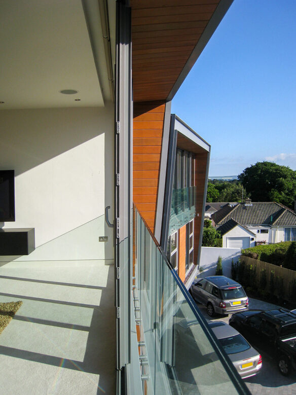 sliding glass doors on first floor revealing balcony with glass balustrade