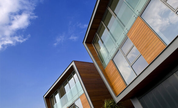 detail of frontage of house with timber cladding a glass balustrade balcony