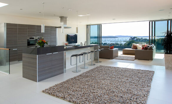 open-plan kitchen and living room with sliding glass doors leading to patio with stunning sea views