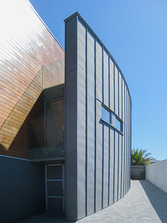 house with timber cladding and a curved zinc wall