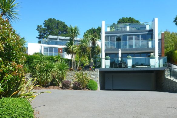 approach view of two contemporary houses with large balconies on each floor with glass balustrade