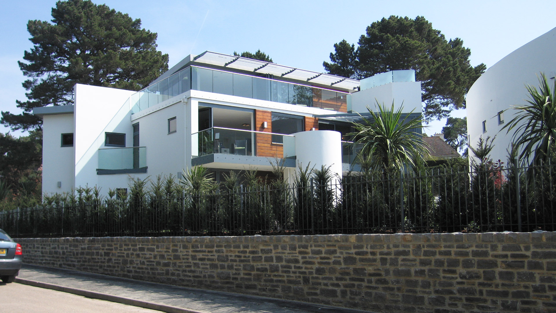 street view of two modern white houses with curved wall and balconies