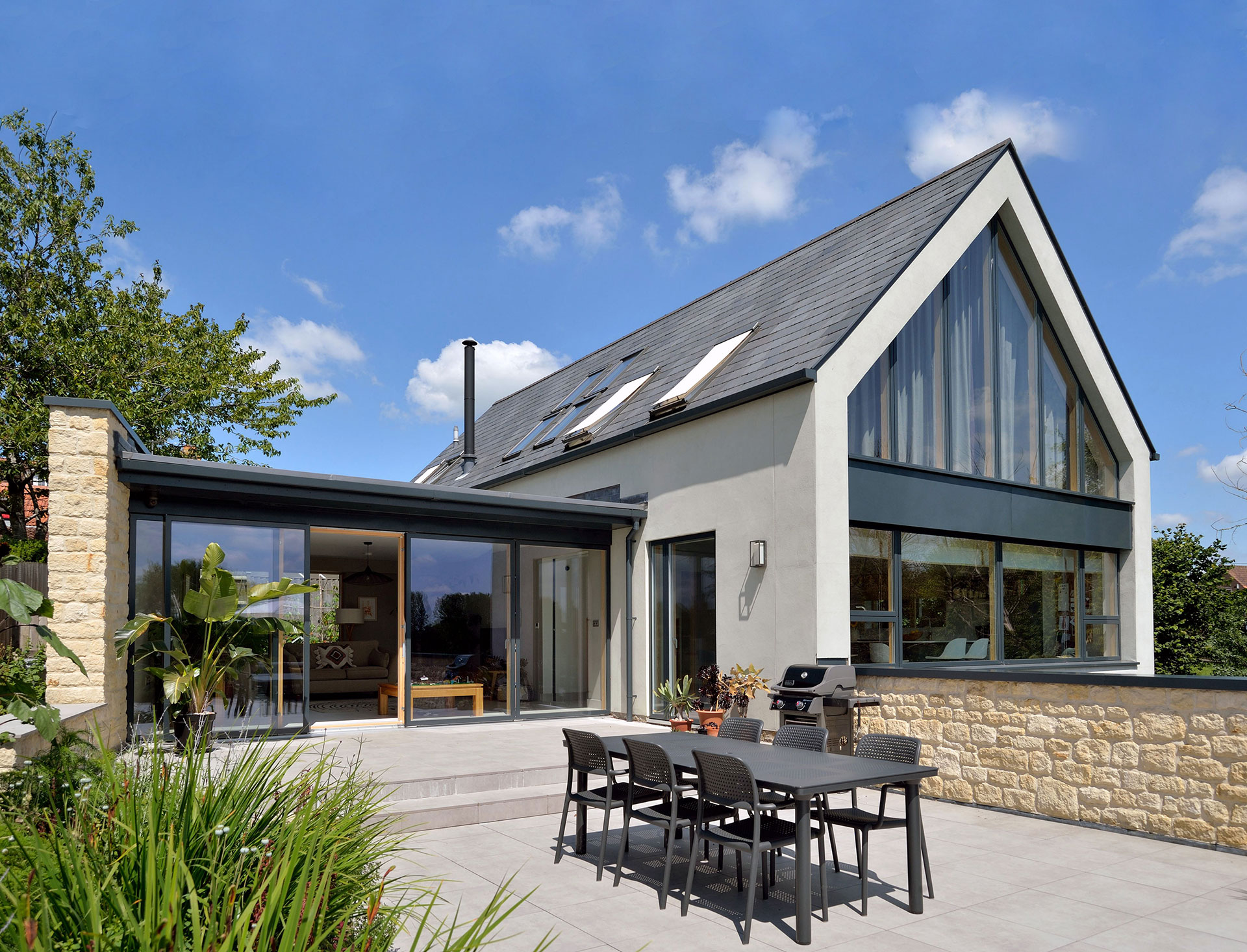 view of house with glazed gable with outside dining area on patio