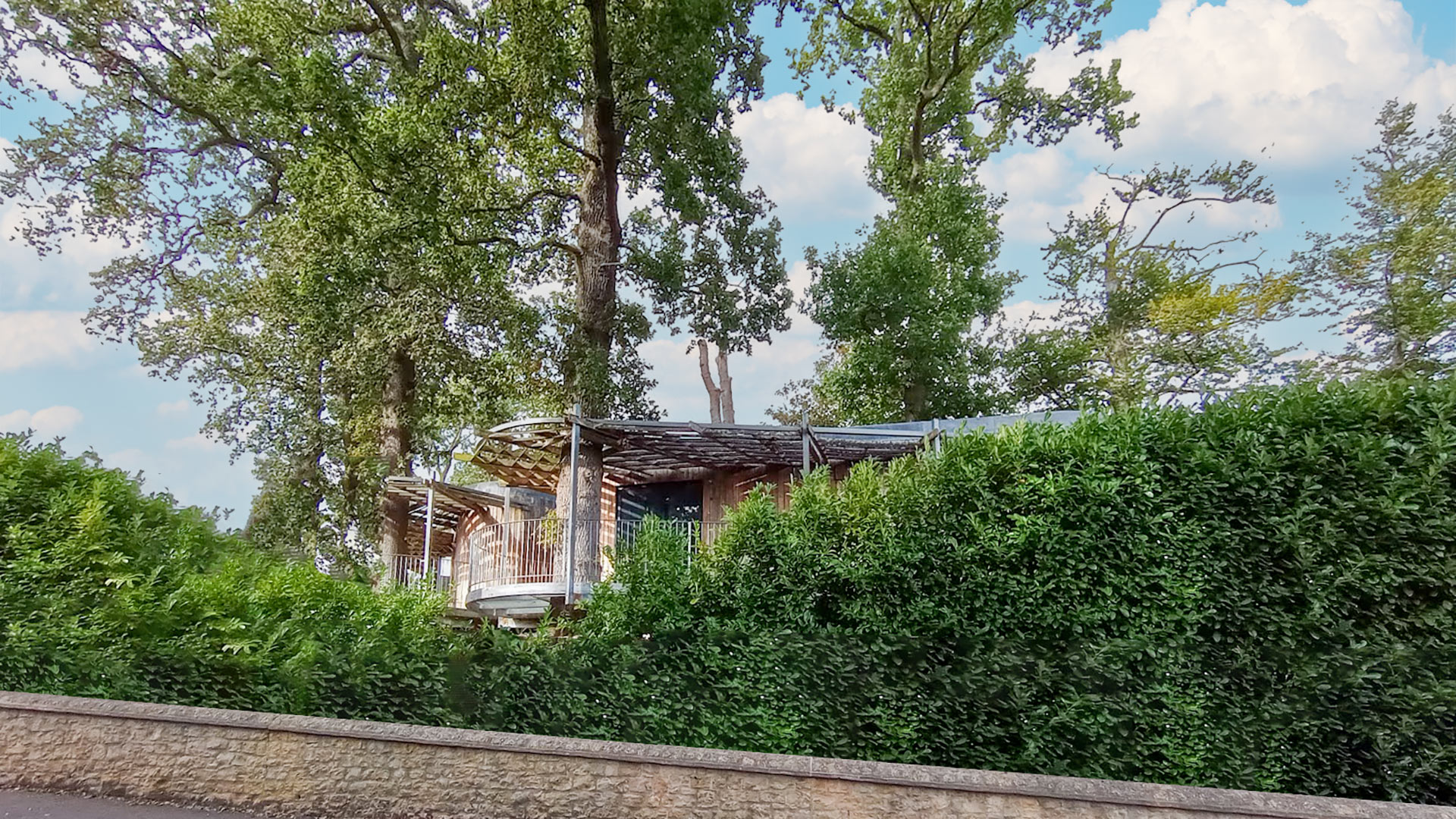 street view of wood clad house with veranda