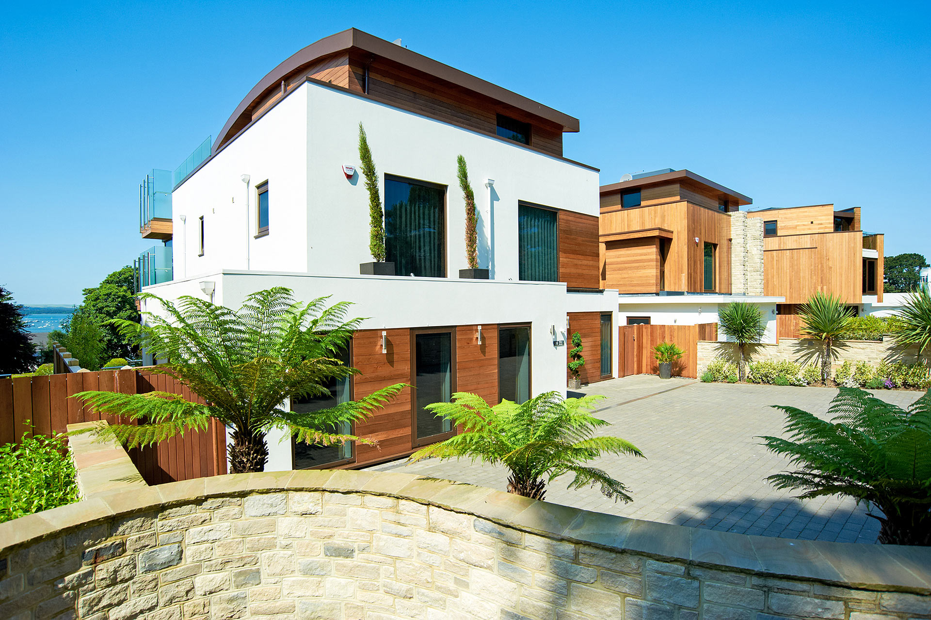 entrance and driveway to contemporary house with curved roof