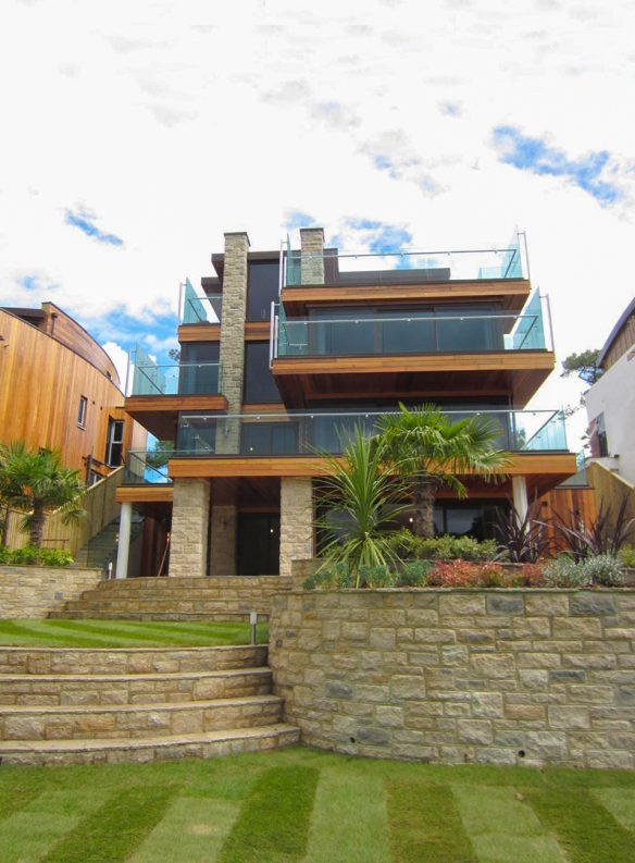 garden view of house with modern linear design and glass balconies