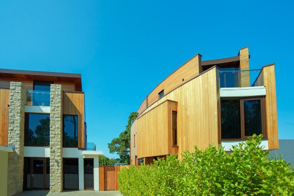 street view of two houses with timber cladding and curved walls