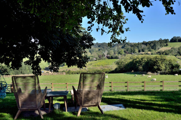 garden chairs over looking a beautiful countryside view with sheep
