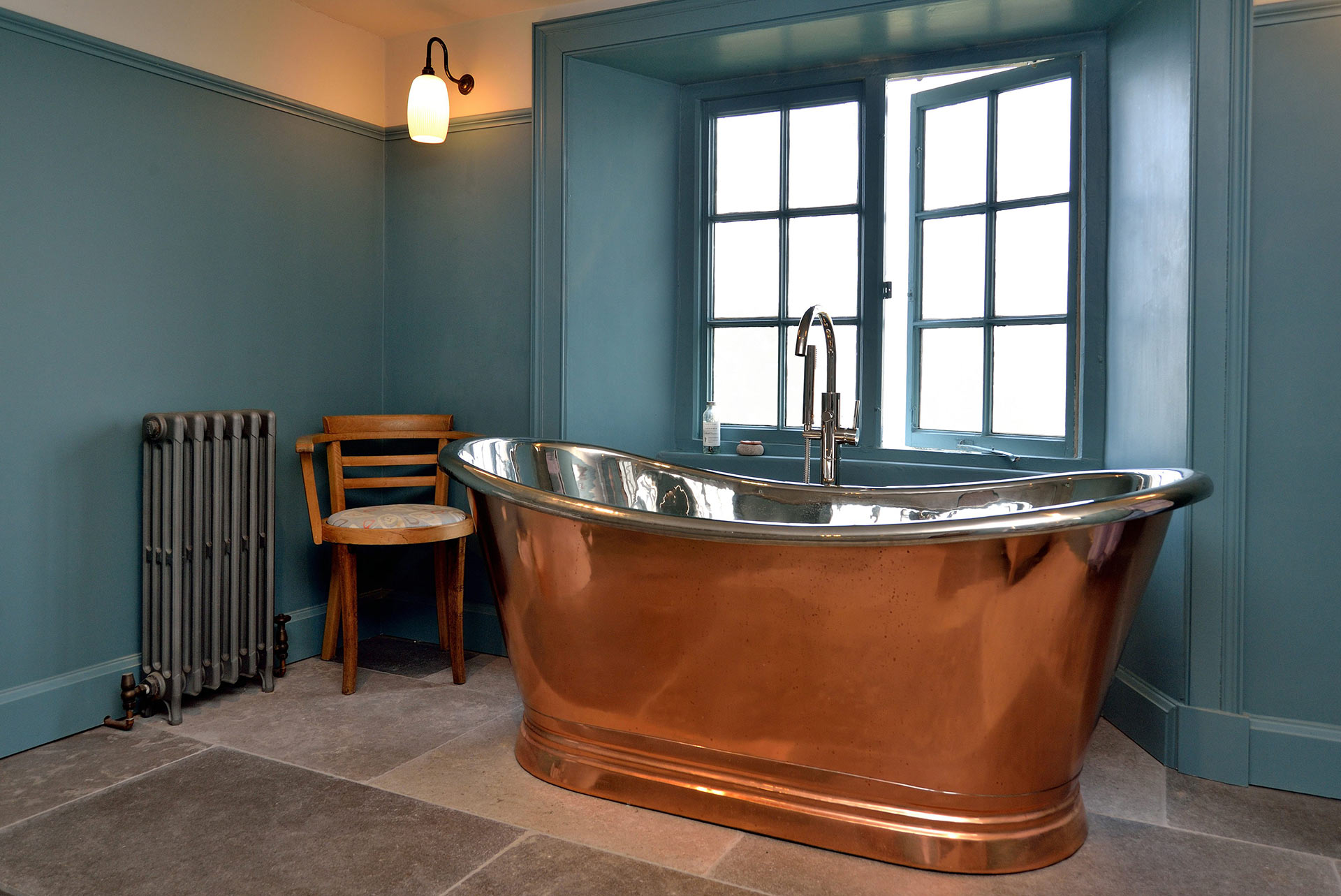 large freestanding copper bath in front of window