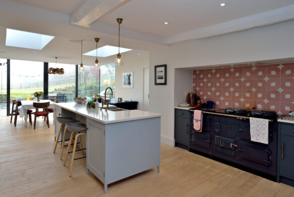 interior open-plan modern kitchen dining area with aga and kitchen island