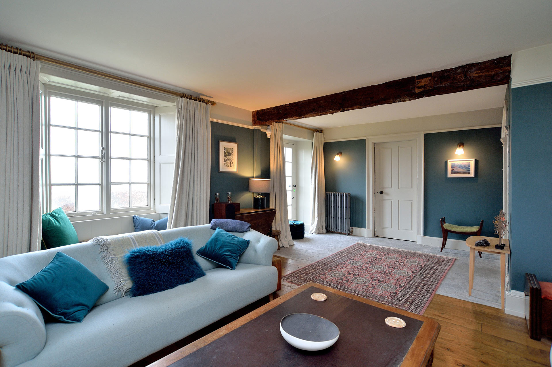 interior living room with exposed wooden beam and large windows