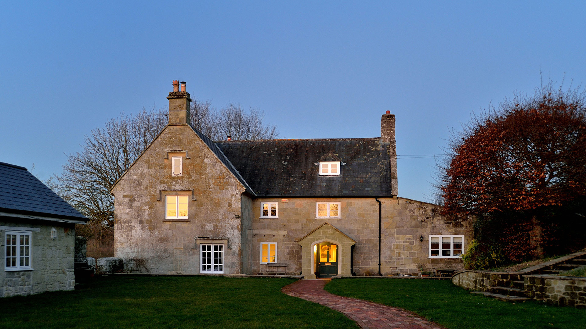 front view of traditional stone house at dusk