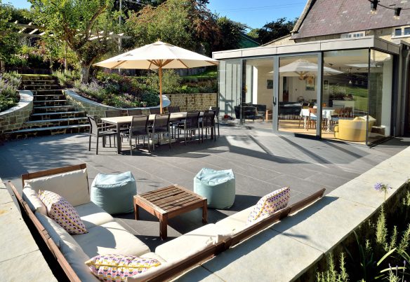 outdoor living dining area on patio with modern extension to house