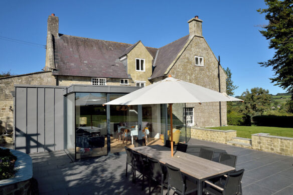 outdoor living dining area on patio with modern extension to house