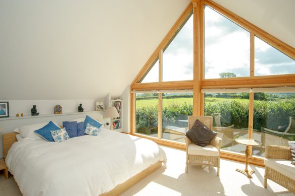 bedroom with vaulted ceilings and large feature window with beautiful countryside views