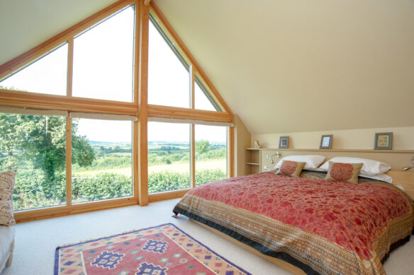 master bedroom with vaulted ceilings and large window feature wall