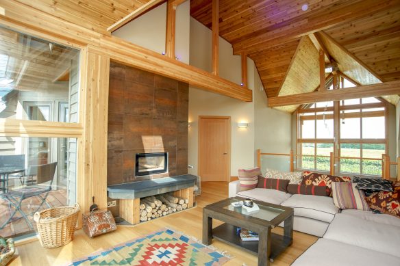 living area space on mezzanine level with double height vaulted ceilings and wood cladding