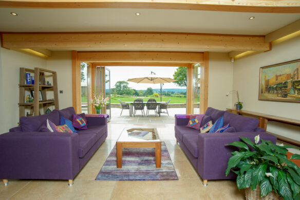 ground floor living area with exposed beams and sliding doors leading to outside dining area