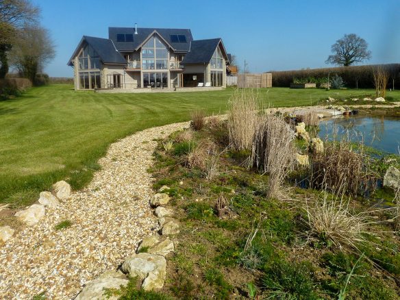 view of impressive pre-fabricated timber house from garden with natural swimming pool