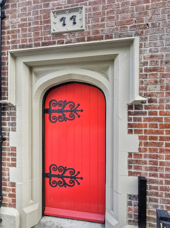 detail of red arched door with stone surround