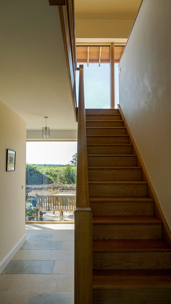 wooden staircase to first floor with hallway on ground floor with views to outside
