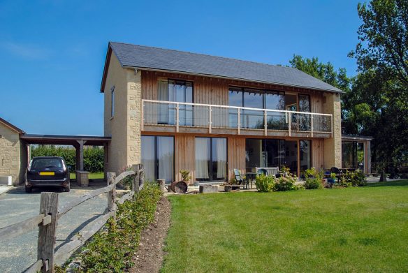 front view of house with timber cladding and first floor balcony