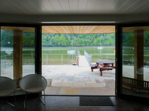 living area with double patio doors leading out to patio area and walkway down to the river