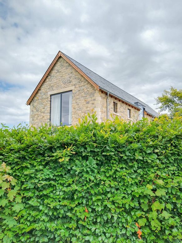 gable end of house from behind hedge