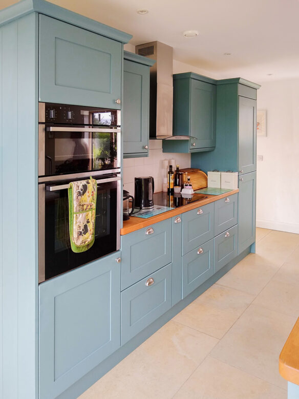 blue kitchen cupboards with oven and hob