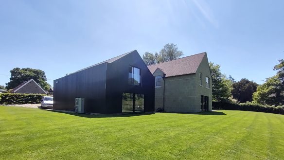 two modern buildings one with black cladding and the other stone