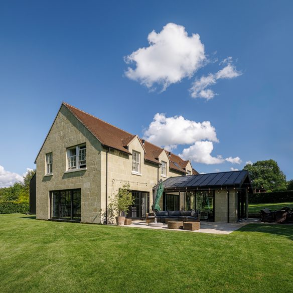 exterior rear view of stone house with extension