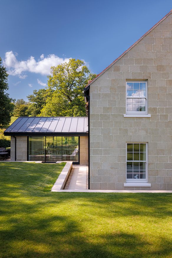 side view of house with stone walls and beautiful modern extension