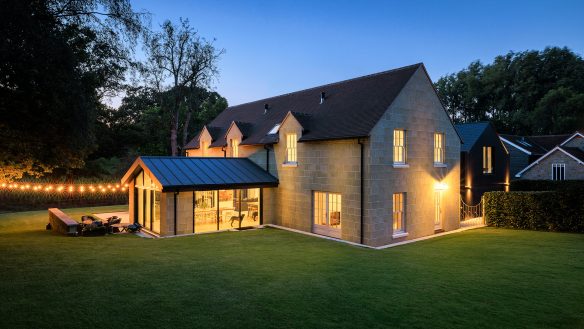 garden view of house at night with lights on