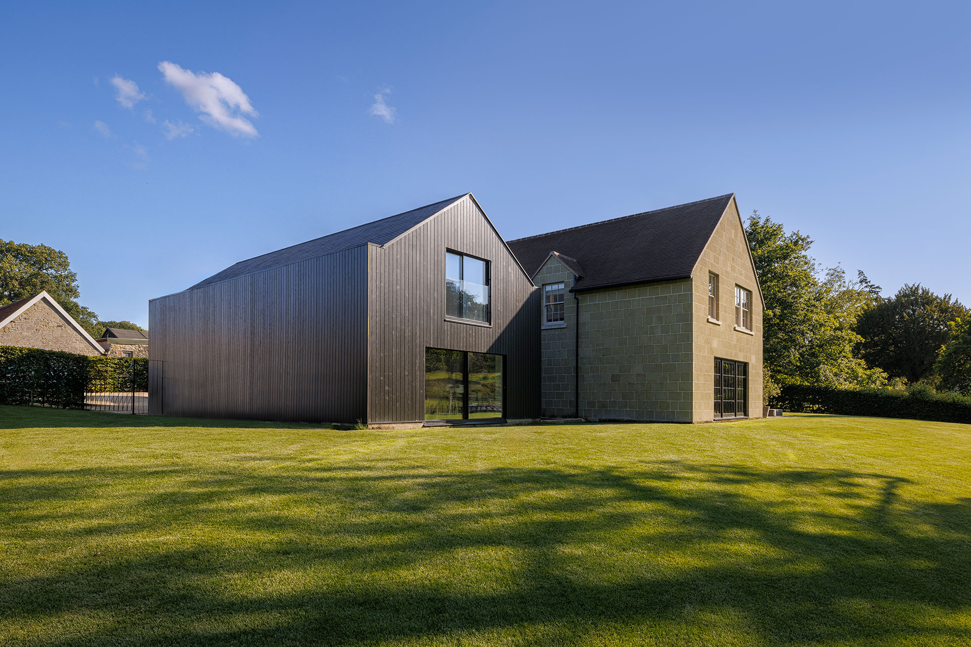 rear view of house with stone and timber cladding and Juliette balcony