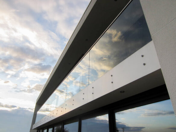 detail photo of balcony with glass balustrade and reflection of the sky