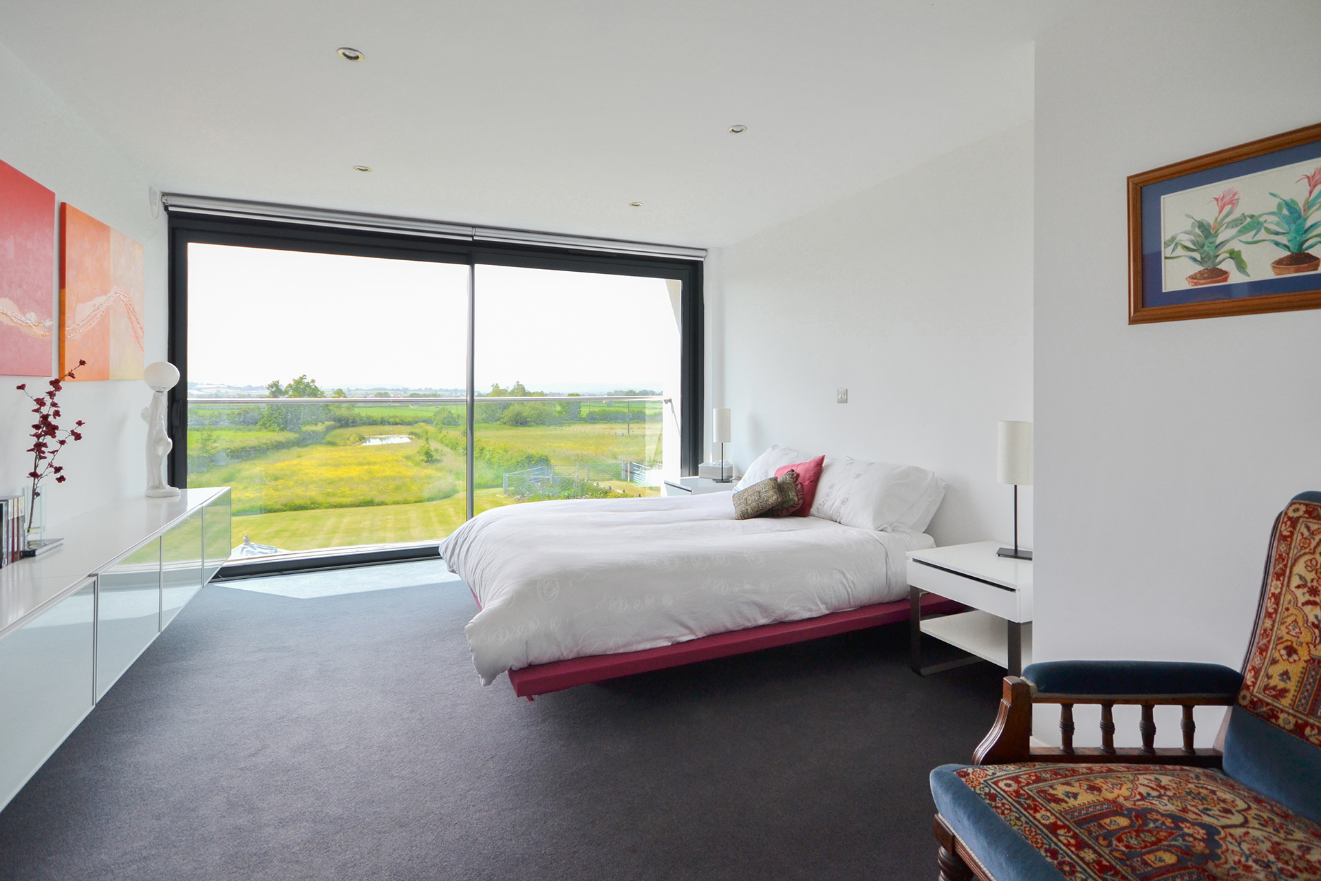 bedroom with large glass windows with beautiful countryside view