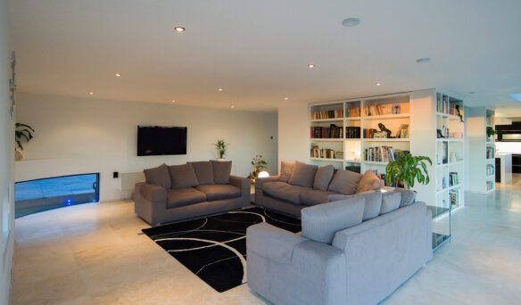 interior open plan living area with feature curved window looking out to moat around house