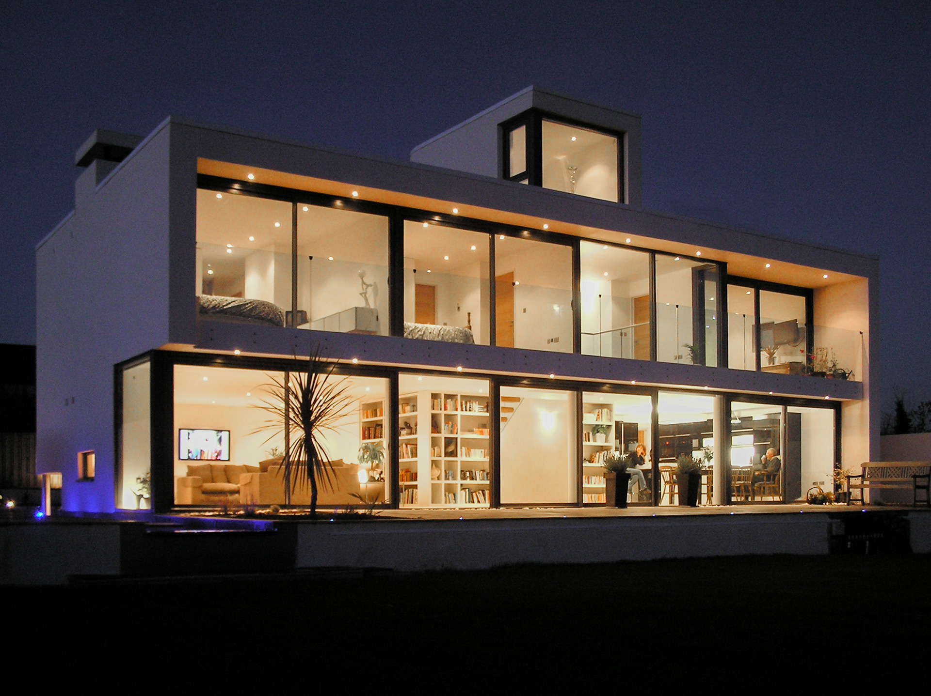 large contemporary house lit up at night