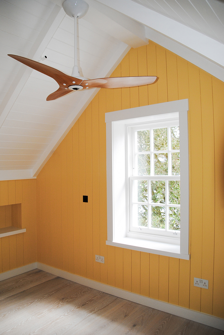 interior bedroom and yellow walls with double aspect windows and a ceiling fan