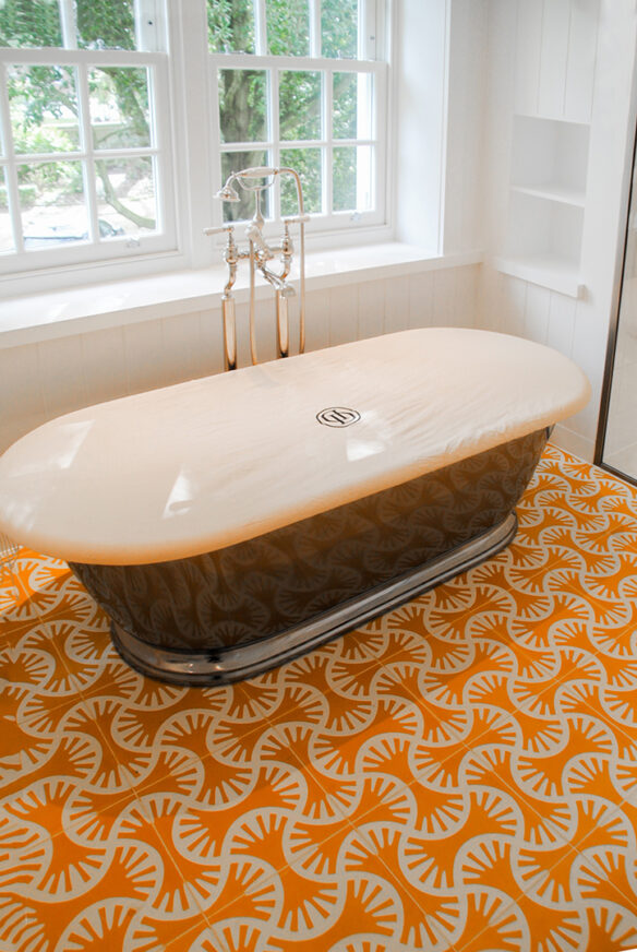 free standing roll top bath with orange floor tiles