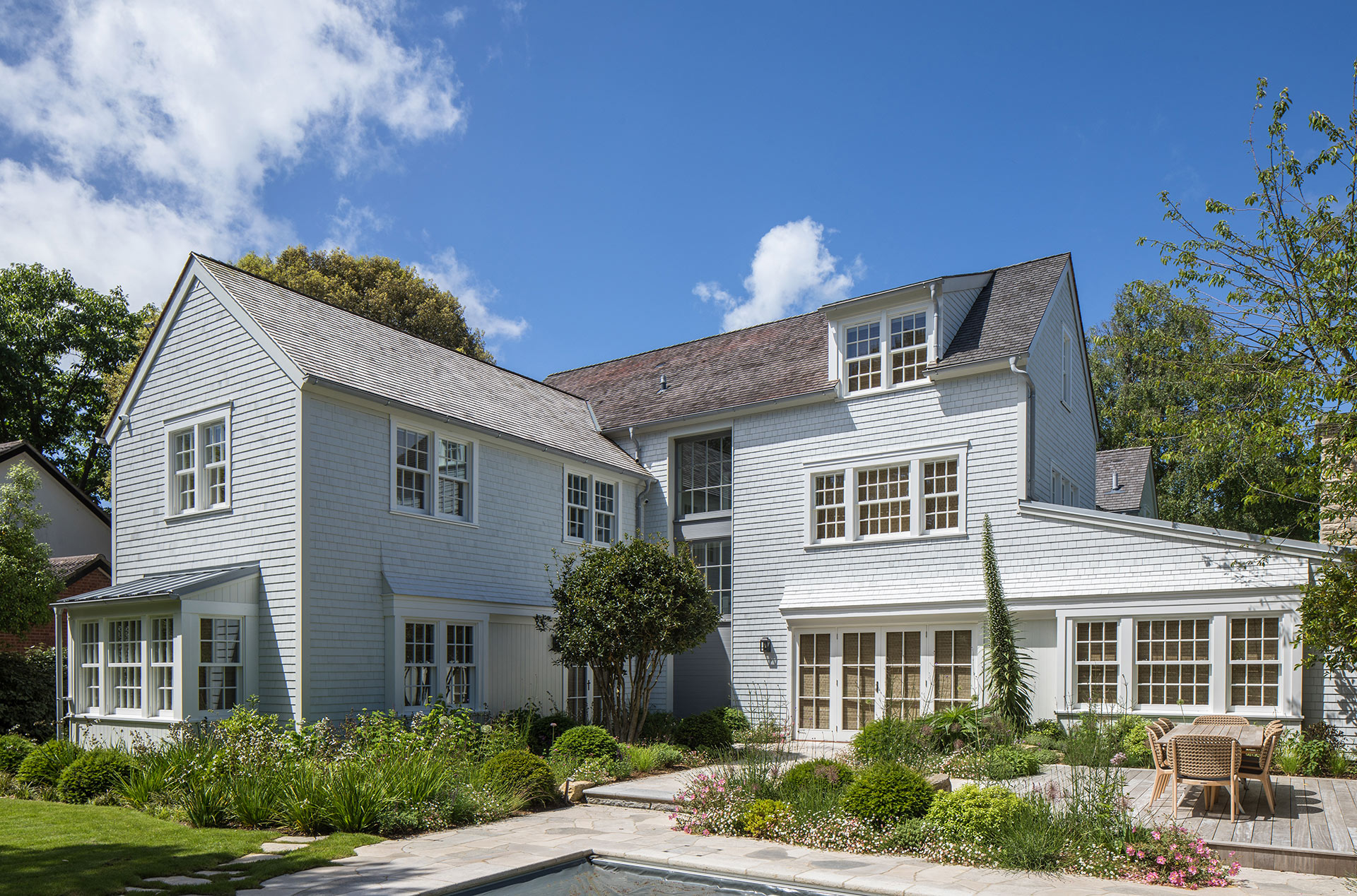 rear view of new England style house with patio garden