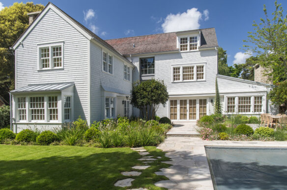rear view of new England style house with patio garden and outdoor swimming pool