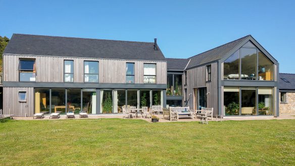 front view of contemporary timer clad house with garden